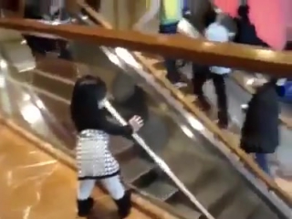 teen girl greets people on the escalator